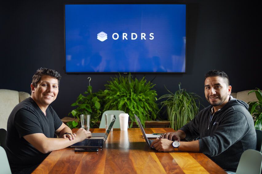 Erik Ibarra and Steven Gonzalez Jr. sitting at desk in ORDRS office